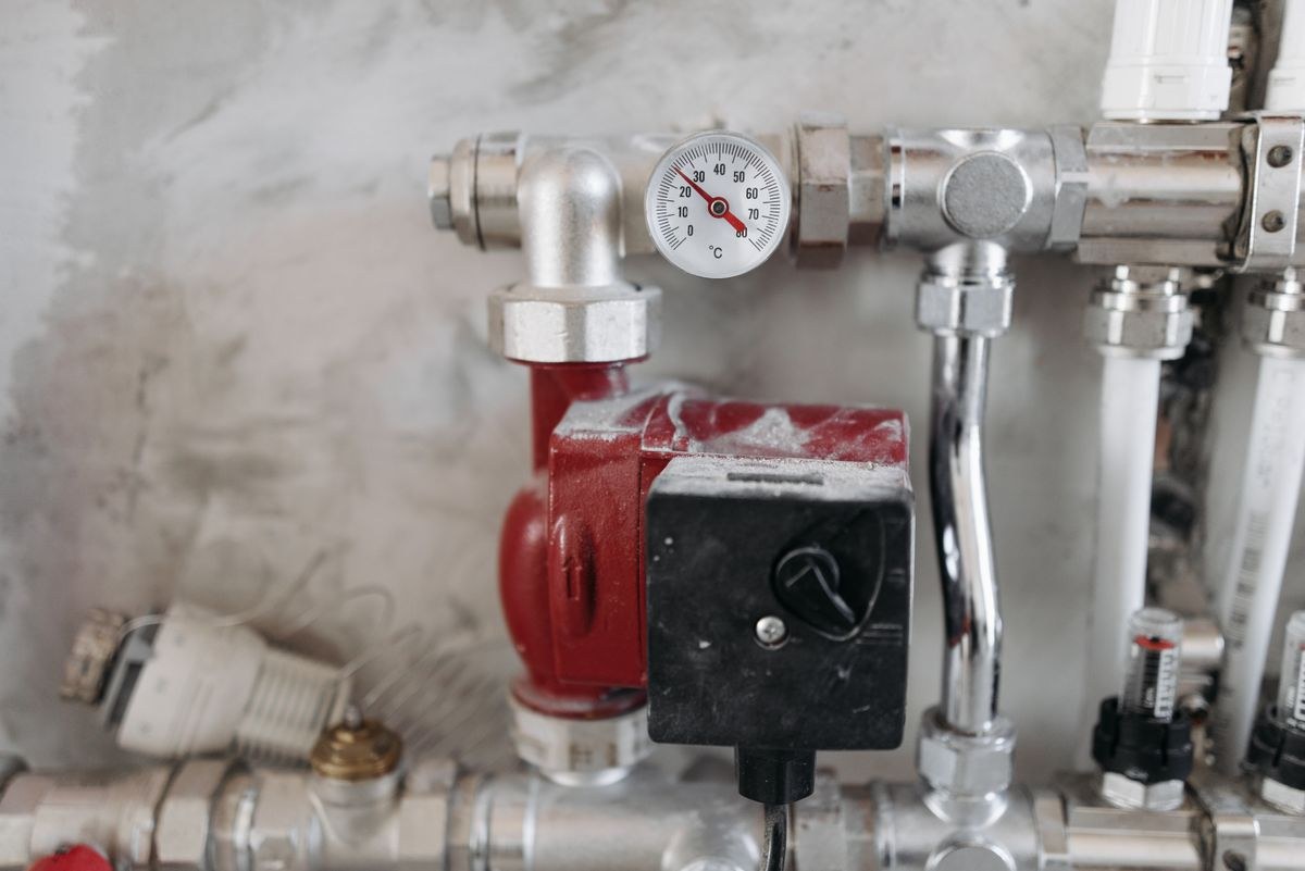 Heizungsverteiler mit Umwälzpumpe und Thermometer im Haus